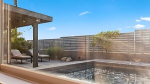 A modern outdoor pool area with a hot tub, lounge chairs, and a pergola. - The Hidalgo House (Desert Hot Springs)