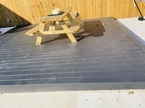 A wooden picnic table with a metal frame, a small black object on the table, and a wooden fence in the background. - Private Lux Home - Separate Lounge - Backyard Oasis - Golf - Fire Pit (Charlotte)