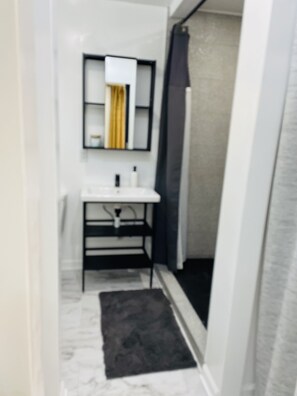 A small bathroom with a white sink, a mirror, and a shower area. - Private Lux Home - Separate Lounge - Backyard Oasis - Golf - Fire Pit (Charlotte)