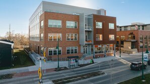 A modern building with a brick facade, large windows, and a visible entrance. - Fir Tree House 307 (Traverse City)