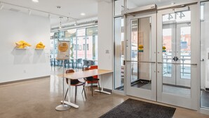 A modern office space with a glass door entrance, a conference table with chairs, and a visible sign indicating 'No Smoking' policy. - Fir Tree House 307 (Traverse City)