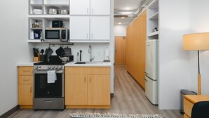 A compact kitchen with a built-in oven, microwave, and a small refrigerator. - Fir Tree House 307 (Traverse City)