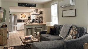 Uma sala de estar moderna com um sofá modular cinzento, uma mesa de centro e um cão.