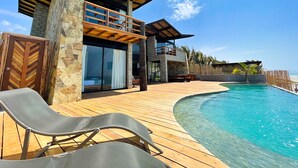 A modern resort with a pool, wooden deck, and a two-story building with large windows. - DIEM Vichayito Beachfront Eco-Luxury (Los Organos)