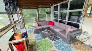 A cozy room with a large window, a sofa, a small table, and a floor mat. - Private Riverfront Home with dock (Hague)