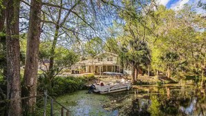 A house by a lake with a dock and a boat. - Withlacoochee River Chalet Great River View, near Rainbow River (Dunnellon)