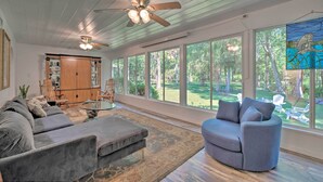 A spacious living room with a ceiling fan, large windows, and a view of the outdoors. - Withlacoochee River Chalet Great River View, near Rainbow River (Dunnellon)