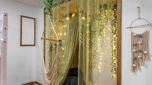 A room with a hanging chair, a dreamcatcher, and fairy lights. - Withlacoochee River Chalet Great River View, near Rainbow River (Dunnellon)