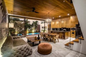Relax in a spacious living and dining area with a plush sofa, wooden coffee table, and modern kitchen.