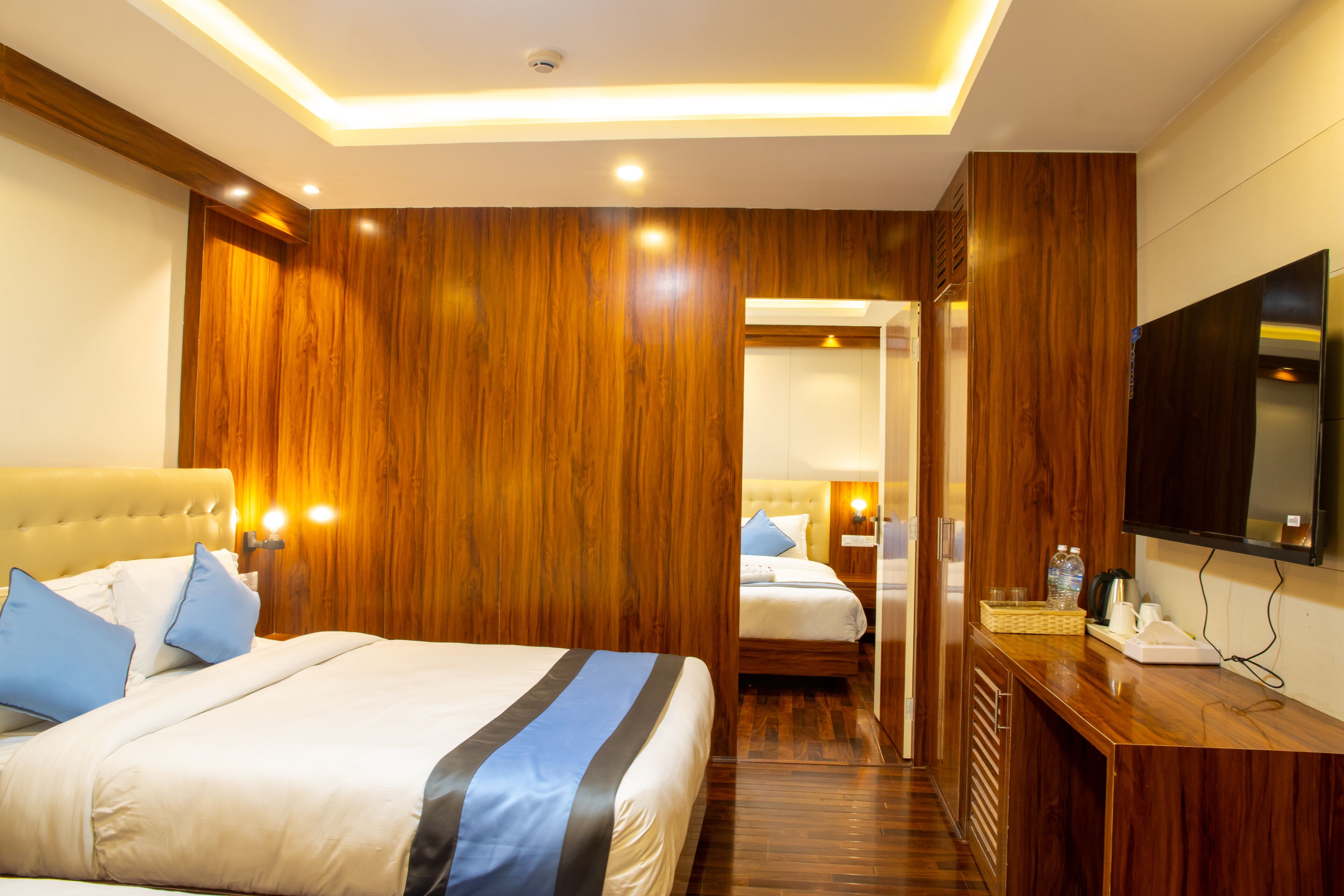 Une chambre d’hôtel avec un grand lit, un bureau doté d’un téléviseur à écran plat et un lambris en bois.