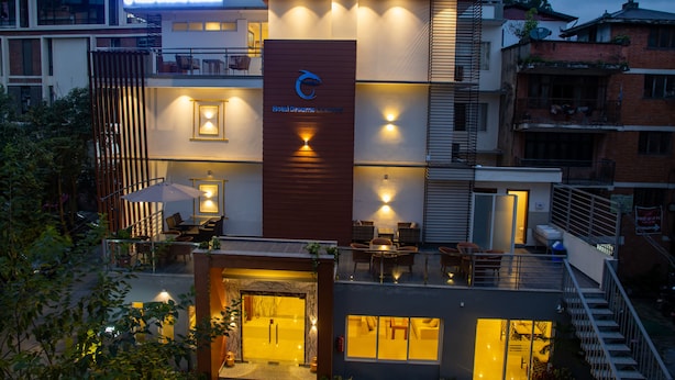 A modern hotel with a prominent logo, outdoor seating, and a well-lit entrance. - HOTEL DREAMS CONNECT (Kathmandu)