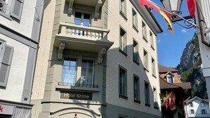 Un edificio con un cartello che indica "Hotel Krone" e una porta in legno.