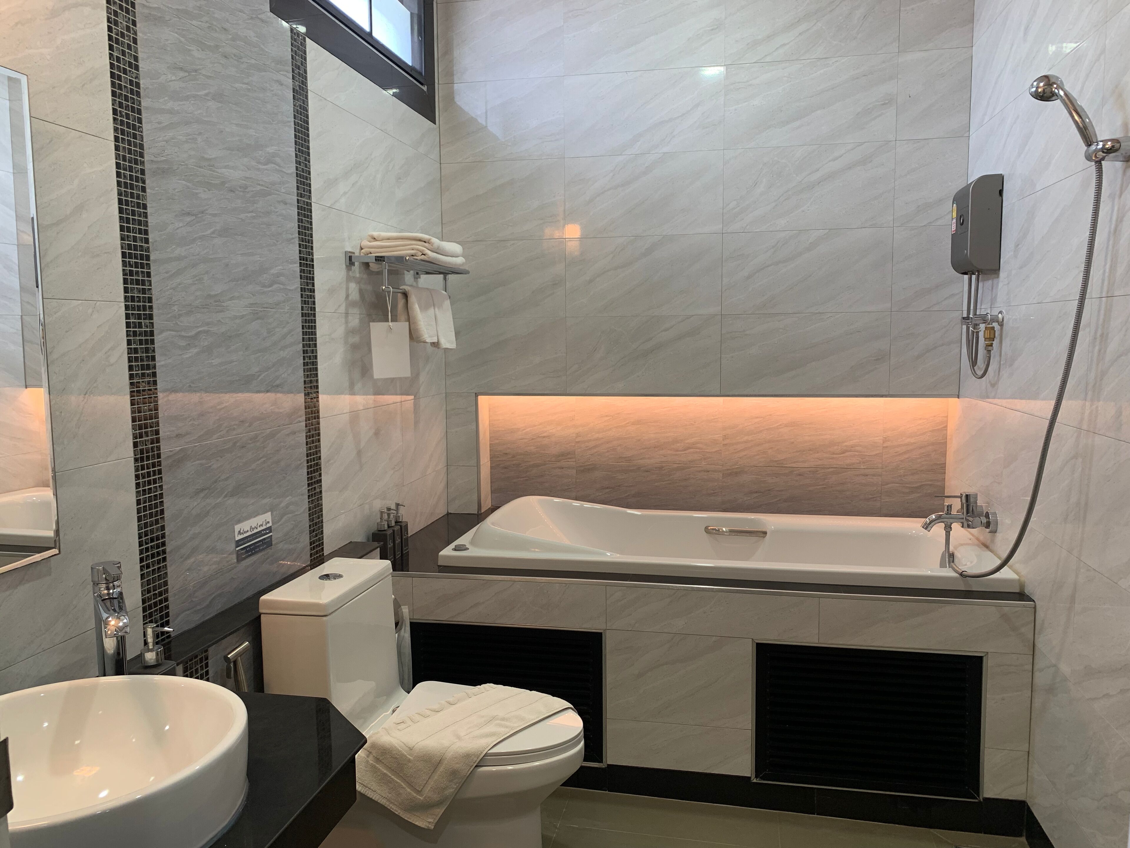 A modern bathroom with a bathtub, a toilet, and a sink.