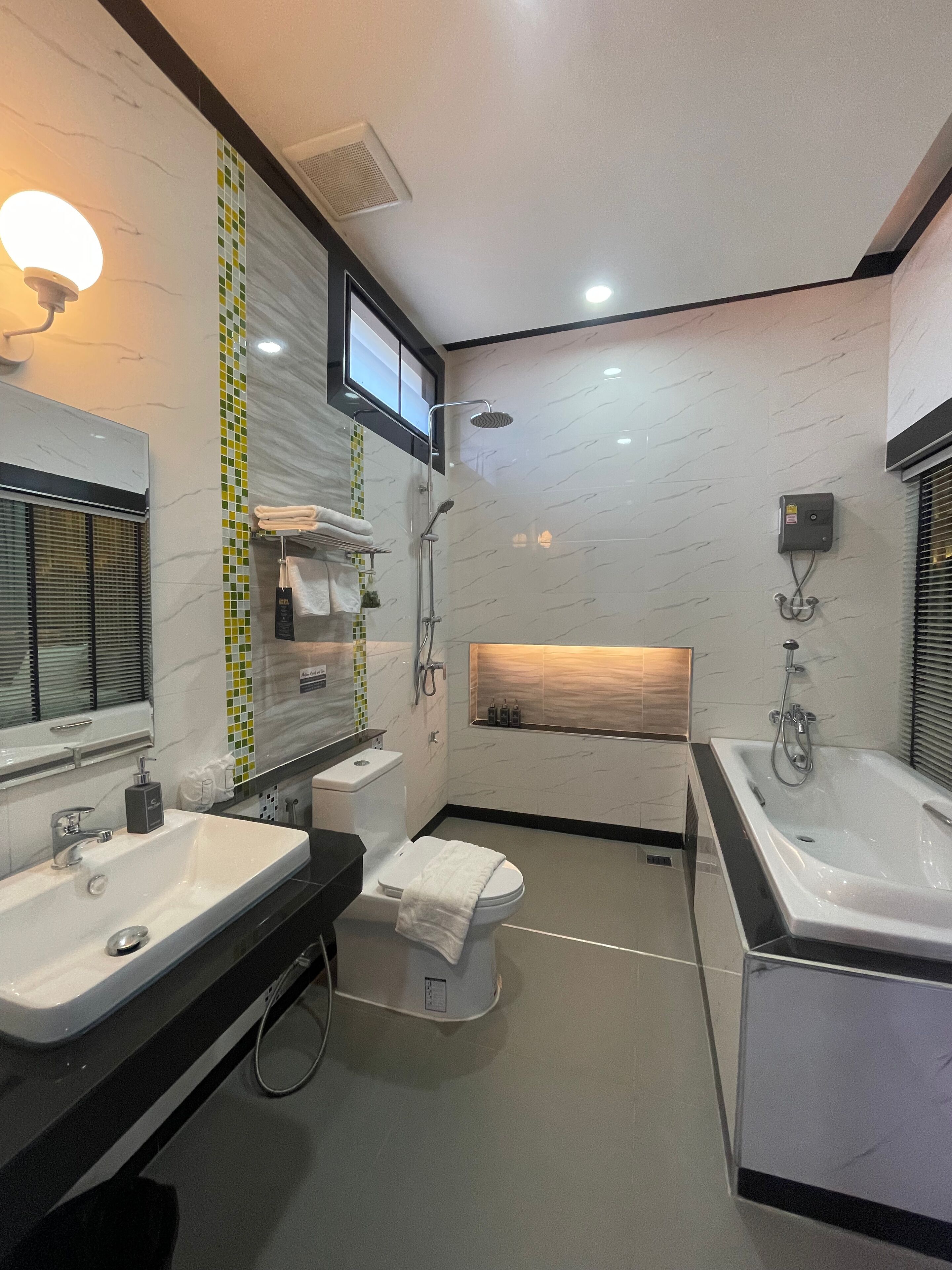 Ein modernes Badezimmer mit zwei Waschbecken, einer Toilette, einer Dusche und einer Badewanne.