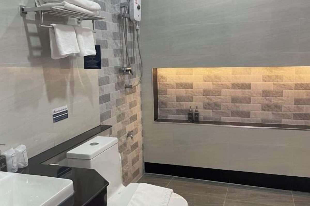 A modern bathroom with a glass-enclosed shower, a toilet, and a sink.
