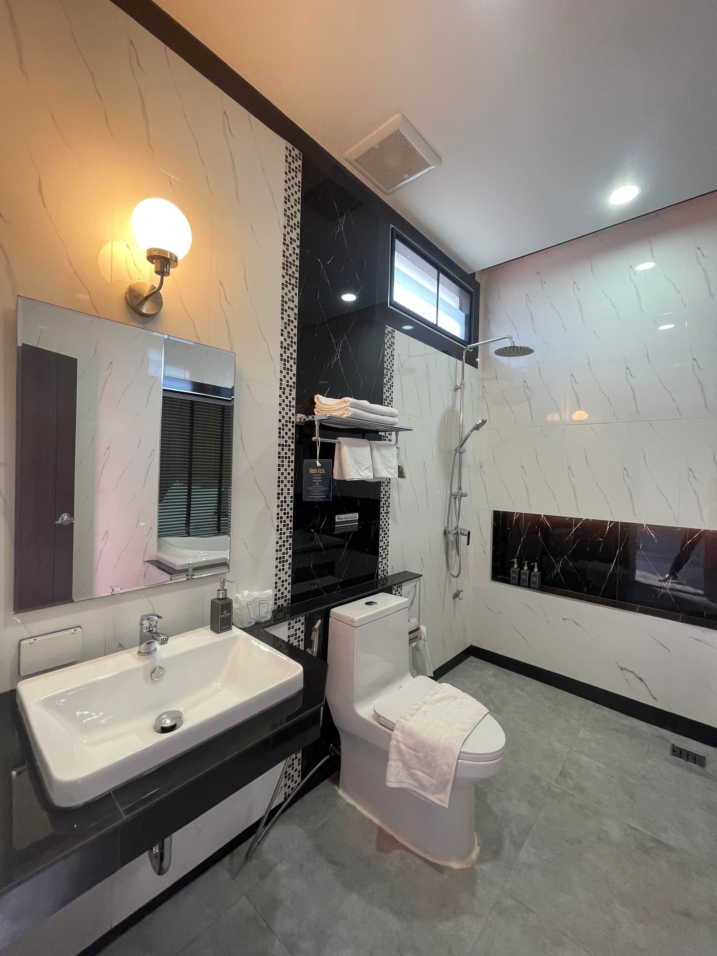 A modern bathroom with a large sink, toilet, and shower.