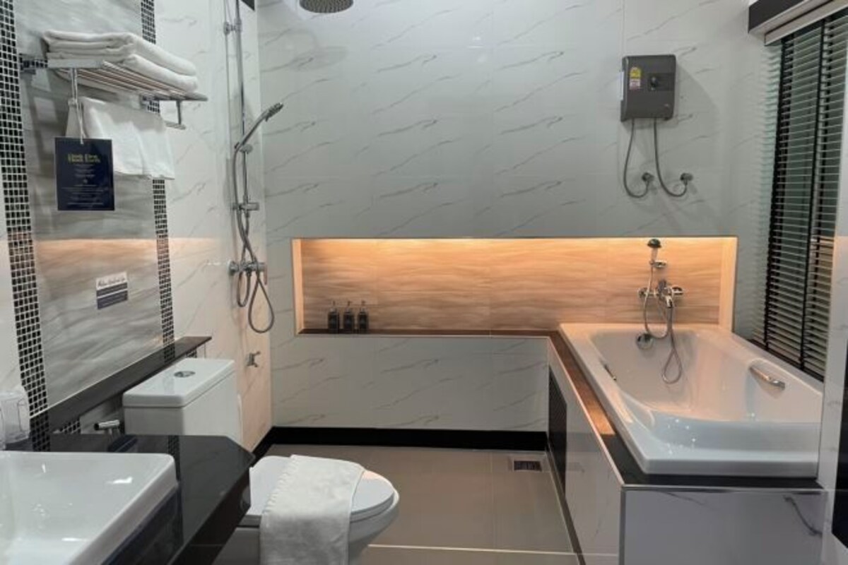 A modern bathroom with a bathtub, toilet, and sink.
