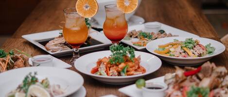 A dining table with various dishes and drinks.