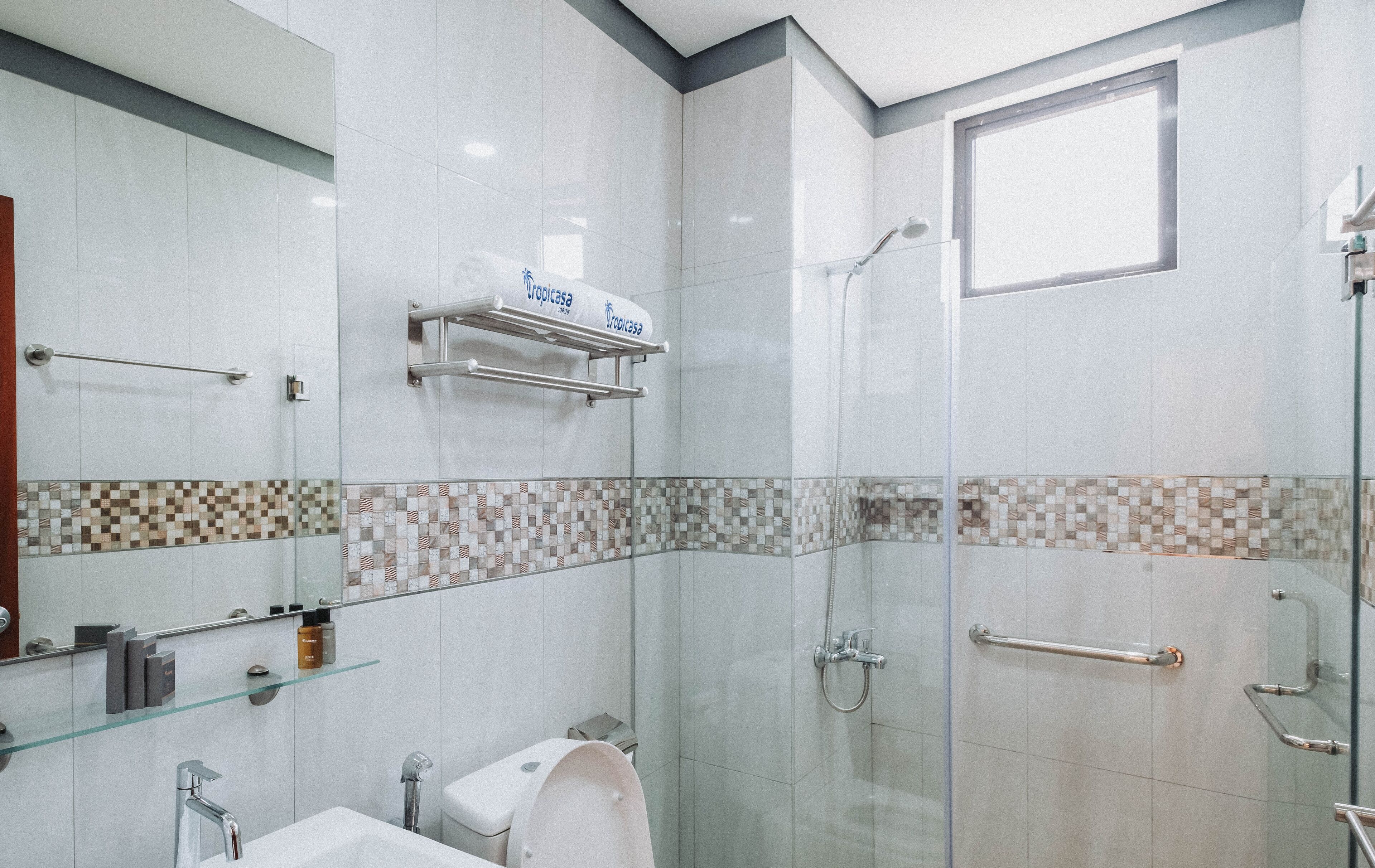 Une salle de bain moderne avec une douche à l’italienne, des toilettes et un lavabo.