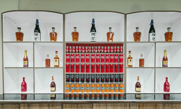 A bar with shelves of various alcoholic beverages, including bottles and cans. - Tropicasa Coron Resort And Hotel (Coron)
