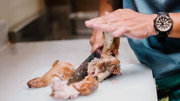 Une personne qui découpe de la viande sur une planche à découper blanche.