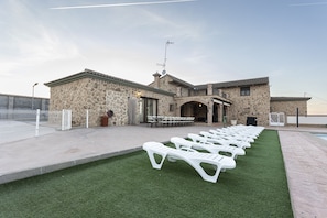 A stone building with a pool area, outdoor seating, and a covered patio. - Casa Rural Abuelo Mauri 4 Estrellas  (Mascaraque)