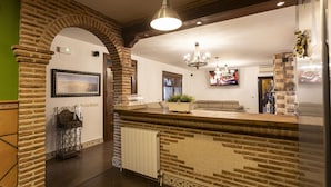 A modern kitchen with a stone archway, a chandelier, and a large window.
