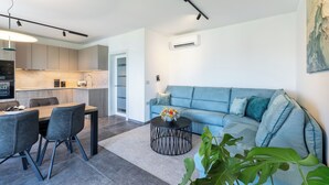 Un salon moderne avec un canapé, une table basse et un coin repas.