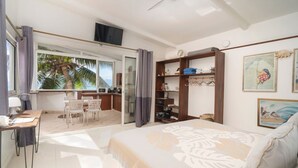Ein Schlafzimmer mit Bett, Schreibtisch, Stuhl, Kleiderschrank und Fernseher.
