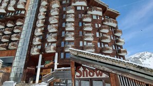 Ein mehrstöckiges Hotel mit Balkonen und einem Schild für einen Skiort.