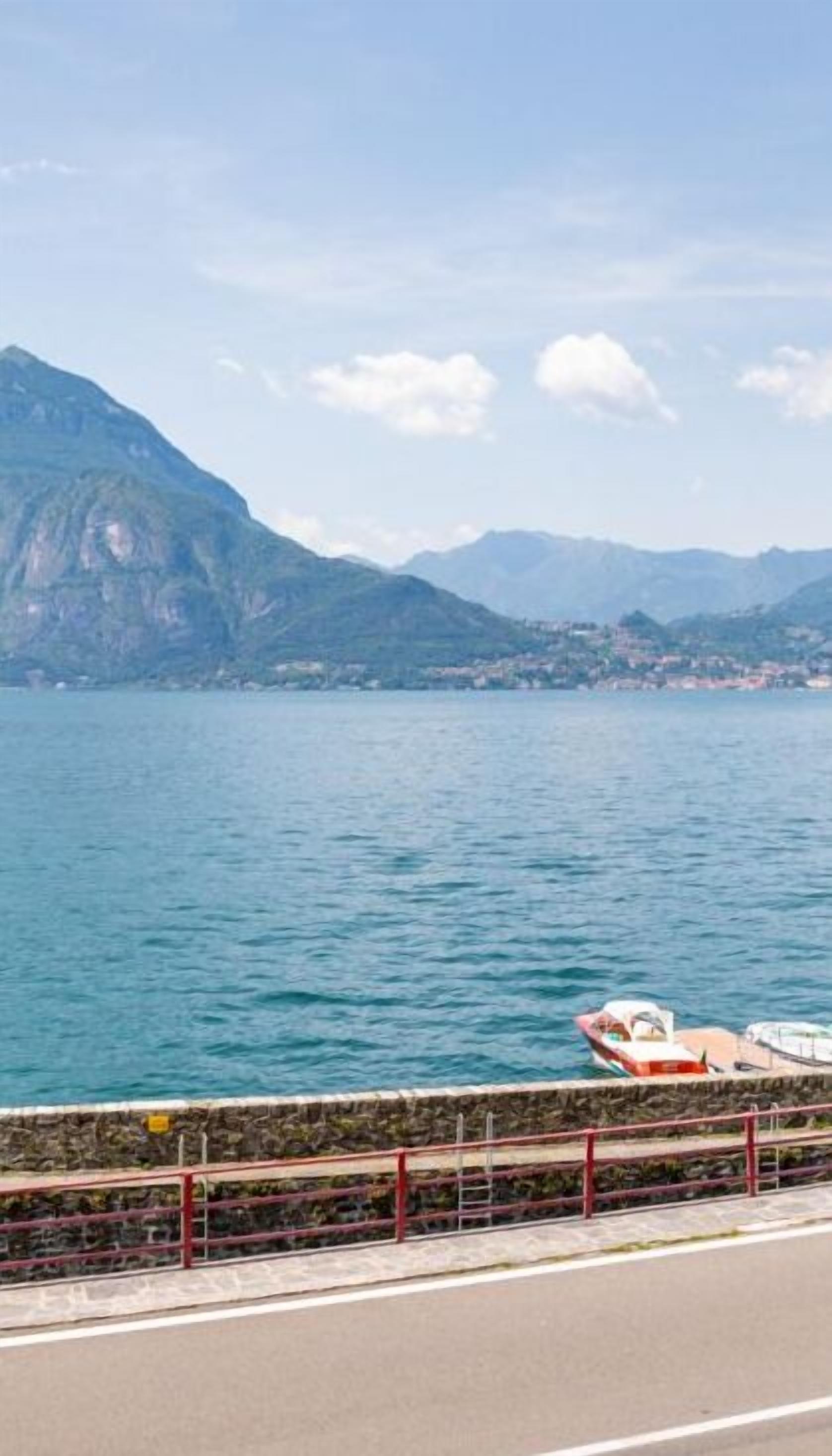A coastal road with a view of a lake and mountains.
