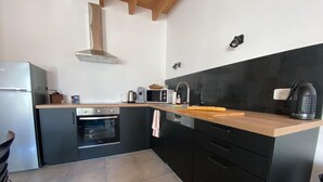 Una cocina compacta con horno integrado, microondas y lavaplatos.