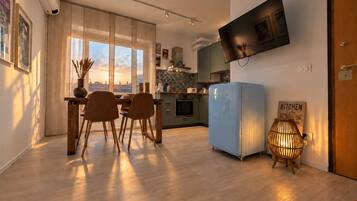 Una cucina moderna con frigorifero blu, tavolo da pranzo in legno e sedie.