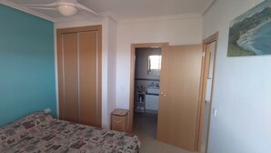 Une chambre à coucher comprenant un lit, une armoire et un petit espace bureau.