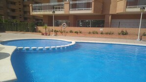 Une piscine à bord incurvé, avec une série de marches circulaires menant à l’eau.