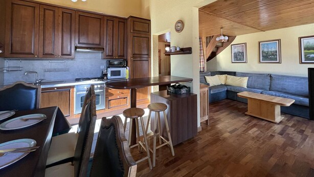Une cuisine spacieuse avec des meubles en bois et un coin repas comprenant une table et des chaises.