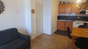 Ein gemütlicher, kompakter Wohnbereich mit Küchenzeile, Essplatz und einer Couch.