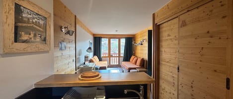 Una habitación compacta con kitchenette, una cama y vistas al exterior.