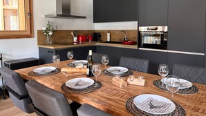 A modern kitchen with dark cabinets, a wooden countertop, and a built-in oven. - Cosy apartment for 6 in Les Gets with WIFI and terrace (Les Gets)