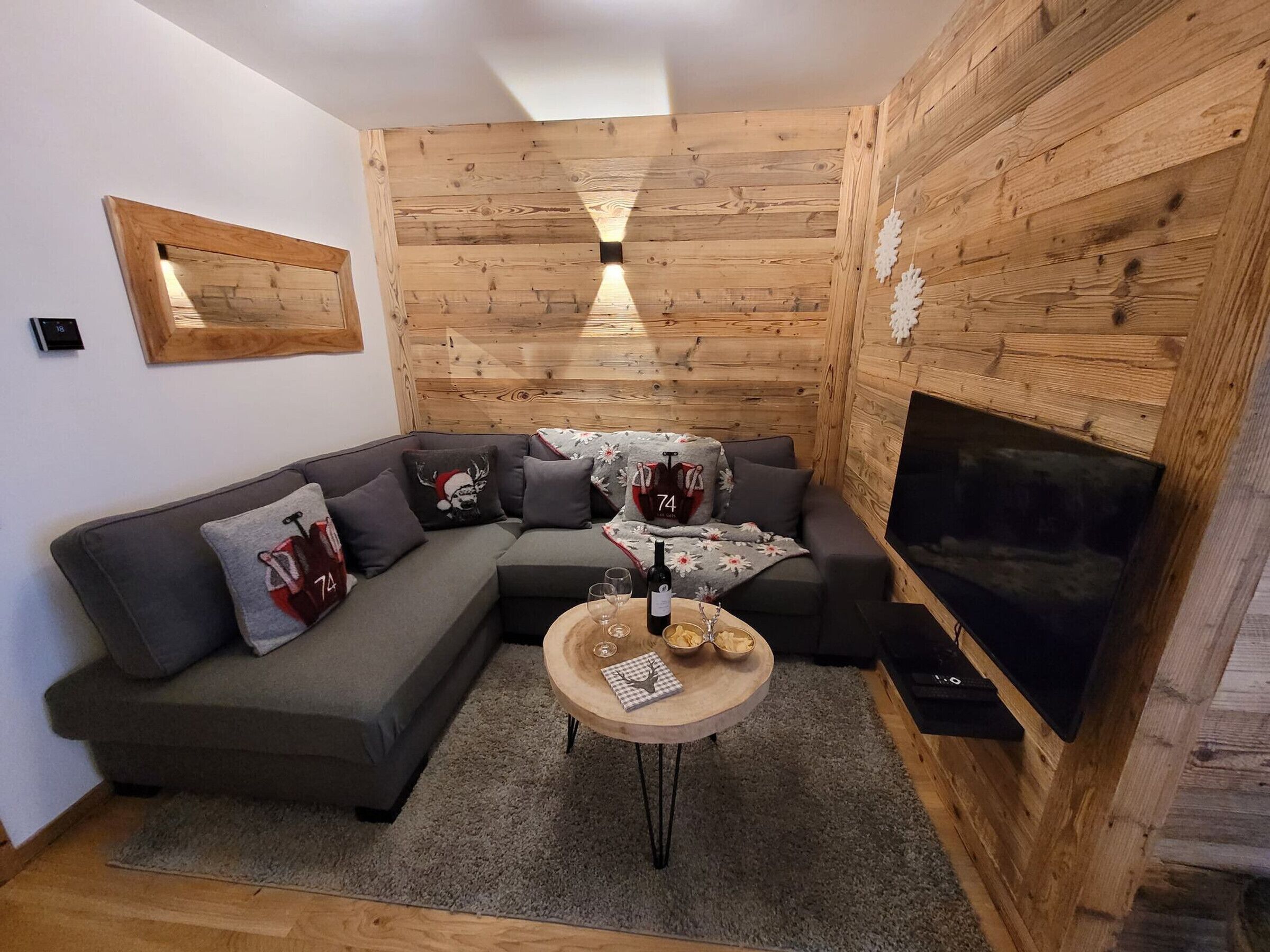 A cozy living room with a sectional sofa, a small wooden coffee table, and a fireplace.