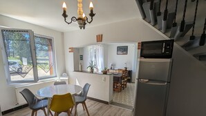 Eine moderne Küche mit Essbereich, einem Kühlschrank und einer Treppe.