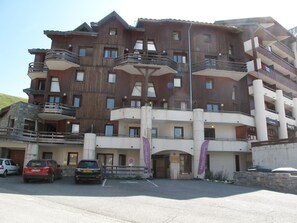Un hotel de varios pisos con balcones, un estacionamiento y un cartel que dice 'Soggetto'.