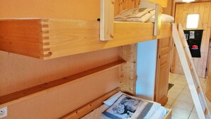 Ein Etagenbett mit unterem Bett und einer Matratze, auf der ein Buch liegt.