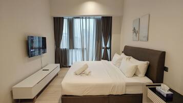 A modern hotel room with a bed, a TV, a bedside table, and a window with curtains.
