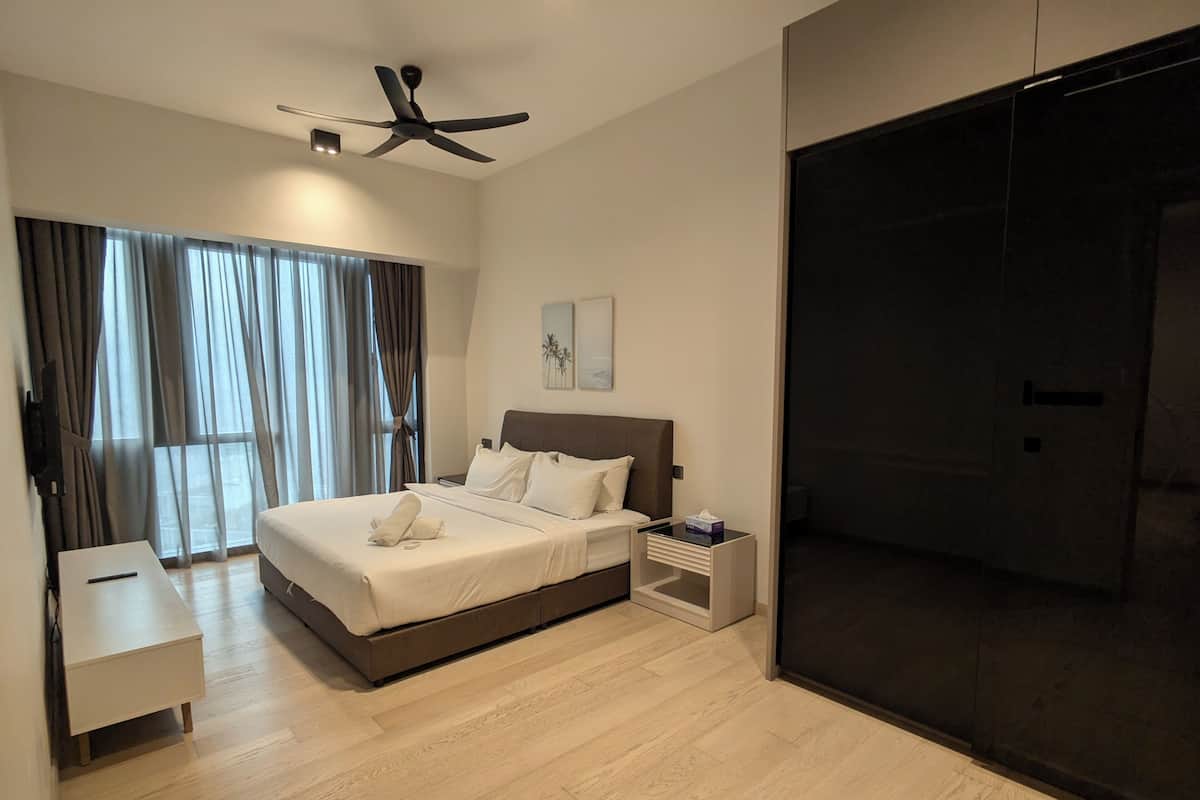 A modern bedroom with a bed, bedside table, and a ceiling fan.