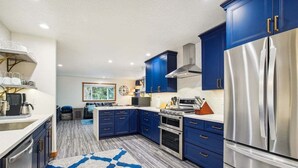 Una cucina moderna con mobili blu, elettrodomestici in acciaio inossidabile e un tappeto decorato.