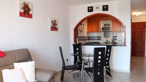 A living room with a sofa and a dining area with chairs and a table.