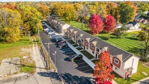 A row of townhouses with a parking lot in front. - Spacious 1BR Flat w/ King Bed & Workspace (Roseville)