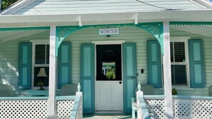 A house with a porch, a door, and a sign that reads "WATERCOLOR". - Watercolor a Charming Island Cottage. 3 Bedroom (Dunmore Town)
