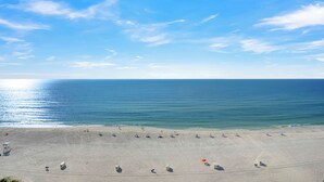Une plage avec un ciel dégagé et une mer calme.